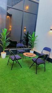 a patio with chairs and a table and grass at فلة جديدة راقية بمسبح داخلي Luxury villa with indoor pool in Taif