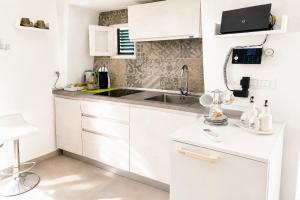 a kitchen with white cabinets and a sink at Venti Nodi in Vieste