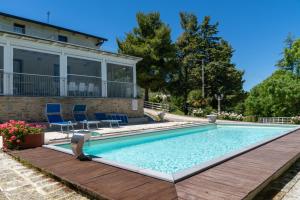 a swimming pool with two chairs and a house at Casa Mattioli in Mombaroccio