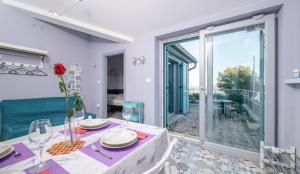 a dining room with a table and a balcony at Home Lotus Flower in Labin