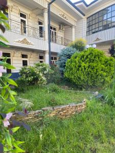 a garden in front of a building at Shodlik Hostel in Andizhan +4 photos