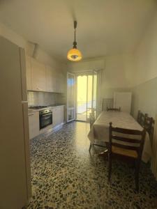 a kitchen with a table and a kitchen with a dining room at Casa vacanza Dominga in Marotta