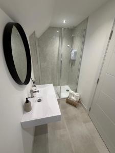 a white bathroom with a sink and a shower at The Esplanade Apartment in Peterhead +11 photos
