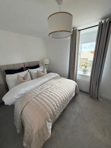 a bedroom with a large bed with a large window at The Esplanade Apartment in Peterhead