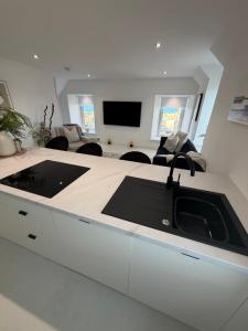 a kitchen with a sink and a living room at The Esplanade Apartment in Peterhead