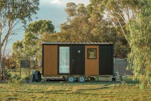 a tiny house on a trailer in a field at D&L Cottage by Tiny Away in Kudla