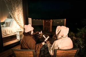 two people sitting at a table looking into a mirror at D&L Cottage by Tiny Away in Kudla +11 photos