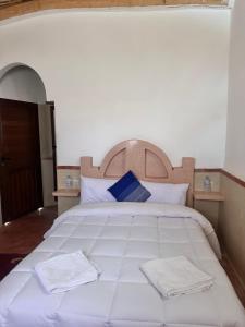 a bedroom with a large white bed with towels on it at Hôtel bleu ciel in Aït Yous +1 photo