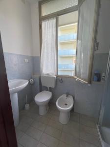 a bathroom with a toilet and a sink at Casa vacanza Dominga in Marotta