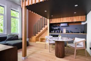 a living room with a table and a kitchen at Villa Weitmar - Apartments und Private Spa in Bochum +64 photos