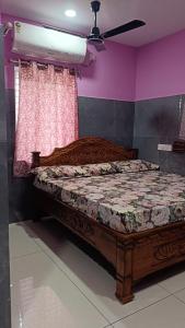 ein Schlafzimmer mit einem Holzbett und einer rosa Wand in der Unterkunft SVS Grands in Ālamūru