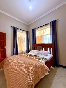 a bedroom with a bed with blue curtains at Eva Residence Arusha in Arusha