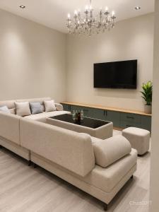 a living room with a couch and a flat screen tv at Beshik Apartment 2 in Samarkand