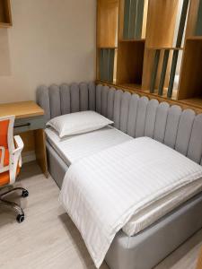 a bed in a room next to a desk and a desk at Beshik Apartment 2 in Samarkand