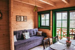 a living room with a couch and tables and windows at Tu W Dolinie in Ropica Górna