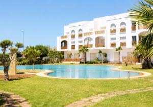 a swimming pool in front of a building at Hara Appart Luxe famille uniquement in Saïdia
