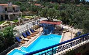 an overhead view of a swimming pool with chairs and an umbrella at Philoxenia Village Hotel-Studios in Pefkochori
