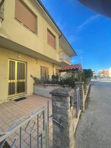 a house with a gate and a brick patio at Casa vacanza Dominga in Marotta