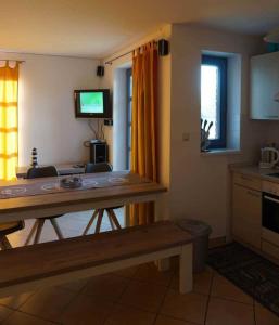 a living room with a table and a kitchen at Ferienhaus Rieke in Friedrichskoog-Spitze