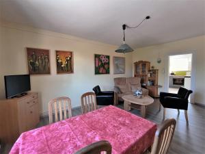 a kitchen and living room with a table and chairs at Familie Hensen - FeWo mit überdachter Terrasse im Ortskern von Tarp in Tarp