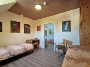 a room with two beds and a table and chairs at Familie Hensen - FeWo mit überdachter Terrasse im Ortskern von Tarp in Tarp