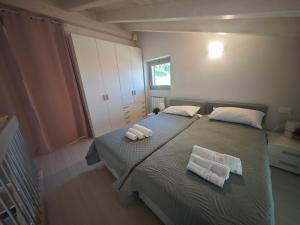 a bedroom with a bed with two towels on it at Casa Rita Fonteno in Fonteno
