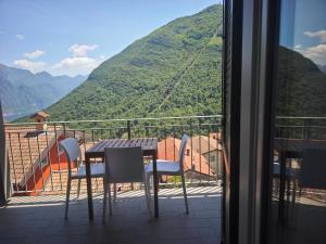 a table and chairs on a balcony with a mountain at Casa Rita Fonteno in Fonteno