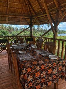 a table with chairs and a table cloth with plates on it at Tangi Elephant Camp in Pakwach East