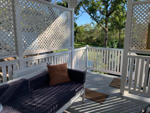 a bench on a porch with a white fence at Kinnoull in Brisbane