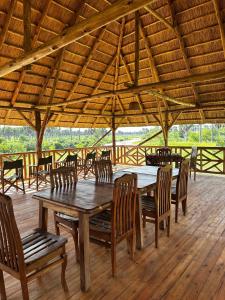 a large wooden table and chairs in a pavilion at Tangi Elephant Camp in Pakwach East