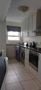 a kitchen with a stove and a washer and dryer at Point Village Accommodation - Alista in Mossel Bay +7 photos