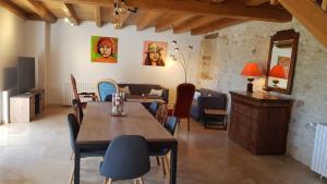 a dining room with a table and chairs and a couch at La truffière in Belvès