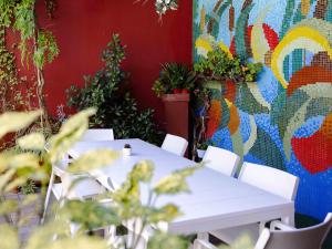 two tables and white chairs in front of a mural at Hotel Ariston in Bibione