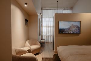 a bedroom with a bed and a chair and a window at Sola Studios in Margaret River Town