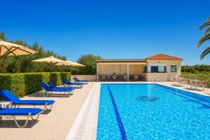 a pool with chairs and umbrellas next to a house at Nautilos Hotel in Soullároi +26 photos