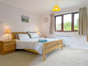 a bedroom with a bed and a large window at Bramley Cottage in Charlton