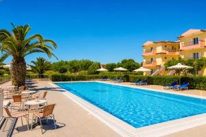 a pool at a resort with chairs and a palm tree at Nautilos Hotel in Soullároi