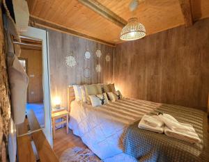 ein Schlafzimmer mit einem Bett und einer Holzwand in der Unterkunft Casa do Azevim in Gavieira