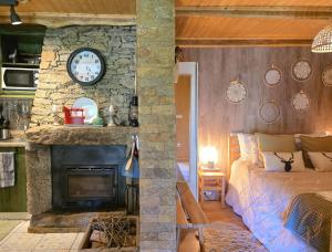 Ein Schlafzimmer mit Steinwand, einem Bett und einem Kamin in der Unterkunft Casa do Azevim in Gavieira