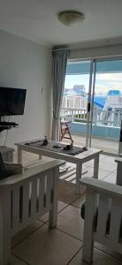 a living room with a table and a large window at Point Village Accommodation - Alista in Mossel Bay