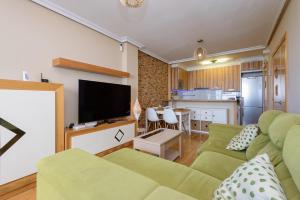a living room with a couch and a flat screen tv at Salinas Surf Paradise in Salinas