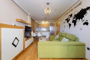 a living room with a green couch and a kitchen at Salinas Surf Paradise in Salinas +34 photos