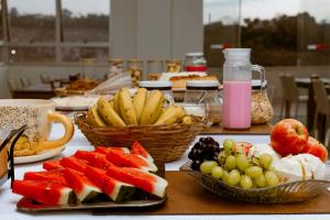 a table topped with plates of fruit and baskets of fruit at SG Apart Hotel in São Gonçalo do Rio Abaixo