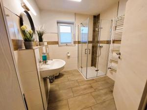 a bathroom with a sink and a shower at FeWo Mäusehaus ID 16291-7 in Kargow