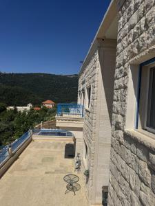 a balcony of a building with a table on a patio at Blue House- Peaceful Mountain Escape in Mazraat et Teffâh +5 photos