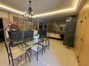 a dining room and living room with a table and chairs at Blue House- Peaceful Mountain Escape in Mazraat et Teffâh