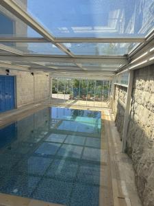 an indoor swimming pool with a glass ceiling at Blue House- Peaceful Mountain Escape in Mazraat et Teffâh