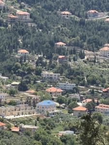 a view of a city with buildings on a hill at Blue House- Peaceful Mountain Escape in Mazraat et Teffâh