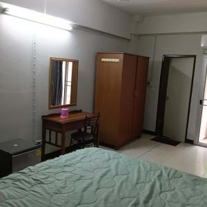a bedroom with a bed and a desk and a table at Viriyapon in Bangkok +1 photo