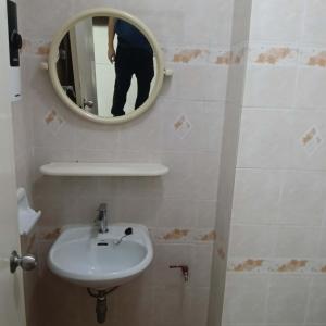 a person taking a picture of a bathroom with a sink at Viriyapon in Bangkok